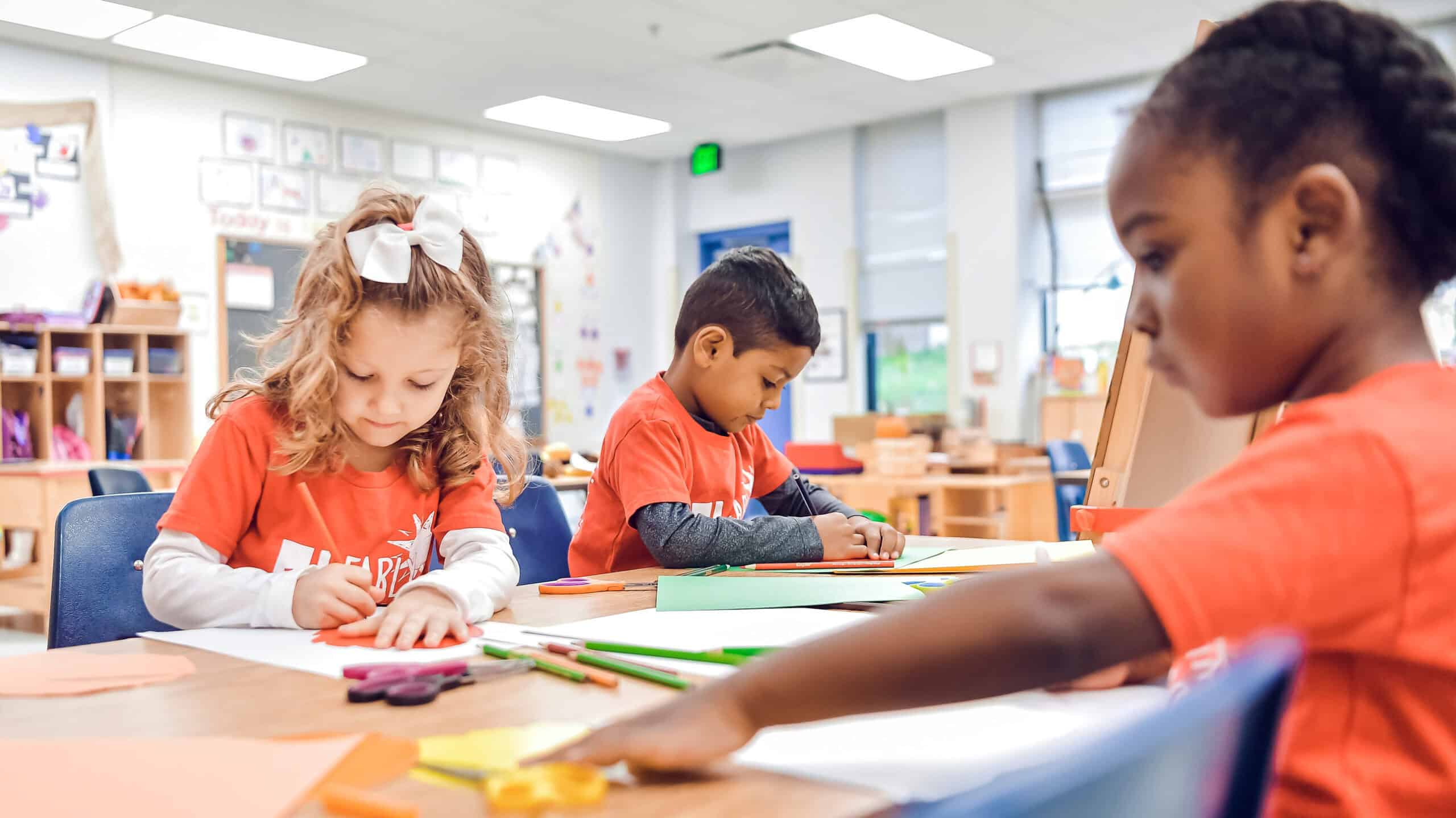preschool children at desks in classroom