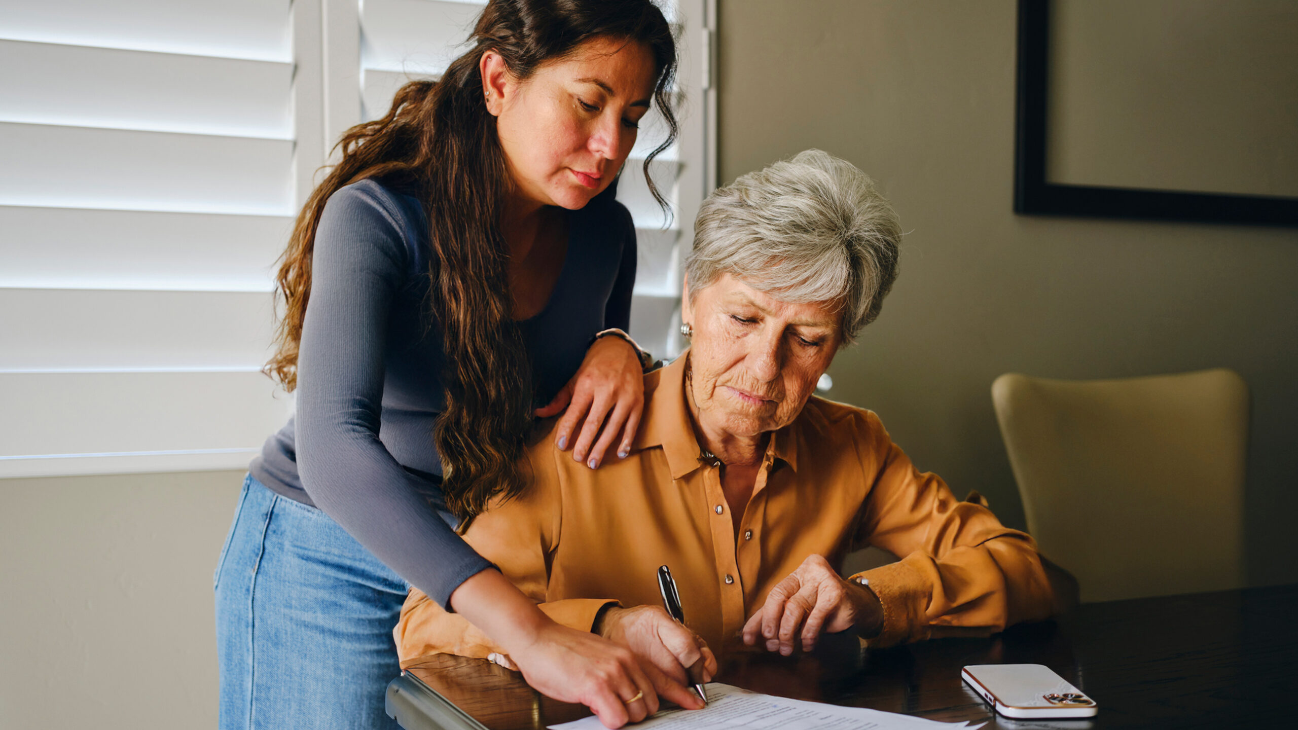 two women planning at desk with paperwork